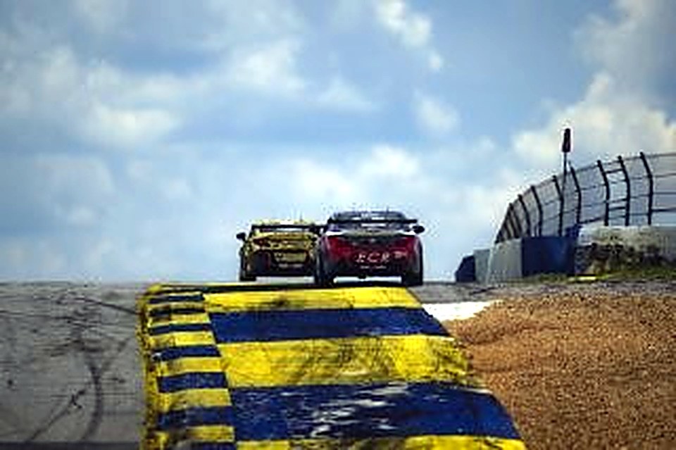 The #90 cresting a hill over striped curbing at Road Atlanta