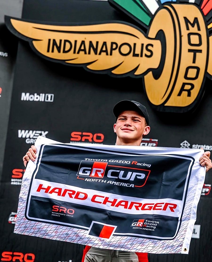 Sugar Wilson on the podium at Indianapolis Motor Speedway holding the GR Cup Hard Charger flag